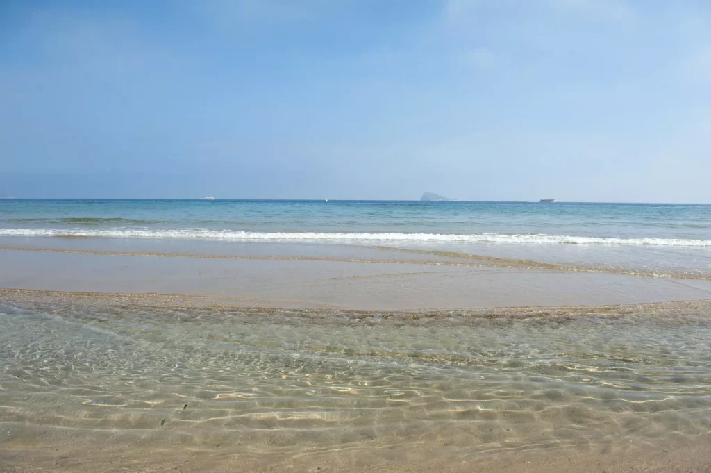 Foto de la orilla de la playa con la isla al fondo